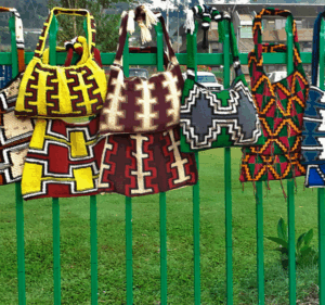 A selection of bilumns hanging on a fence at a market